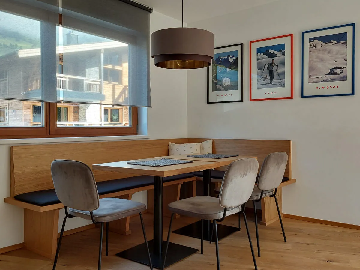 Essbereich mit Tisch, Stühlen und Bildern an der Wand